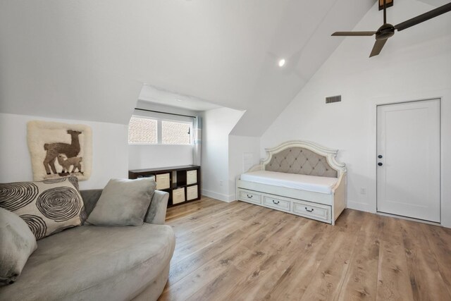 living area with lofted ceiling, ceiling fan, and light wood-type flooring