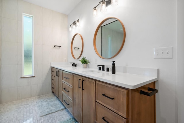 full bathroom with double vanity and a sink