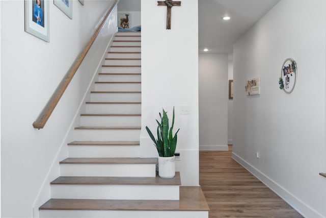 stairway with recessed lighting, baseboards, and wood finished floors