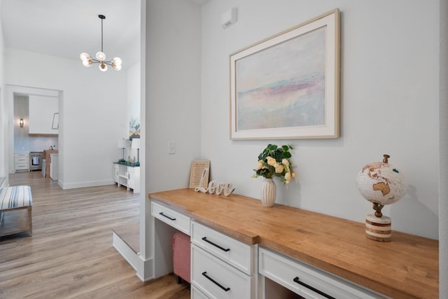 interior space featuring baseboards, an inviting chandelier, and wood finished floors