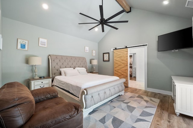 bedroom featuring ceiling fan, beam ceiling, high vaulted ceiling, a barn door, and light wood-type flooring