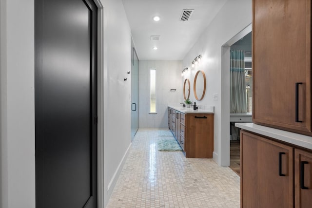 bathroom with elevator, vanity, and a shower with door