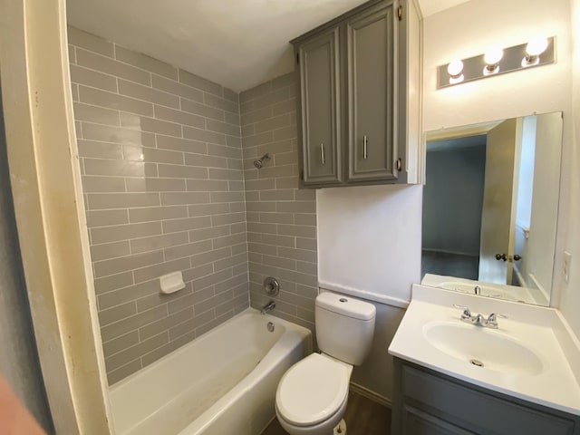 full bathroom with vanity, tiled shower / bath, and toilet