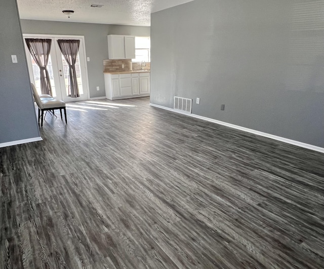 4507 54th St, Lubbock, TX 79414 - unfurnished living room featuring dark wood-type flooring and a textured ceiling