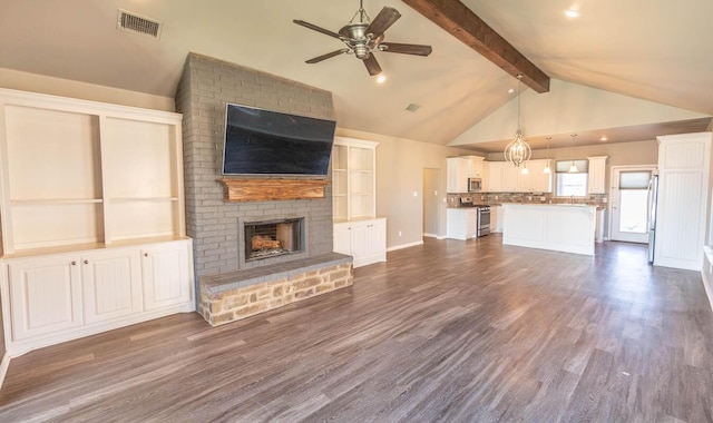 unfurnished living room featuring ceiling fan, dark wood-type flooring, vaulted ceiling with beams, and a fireplace