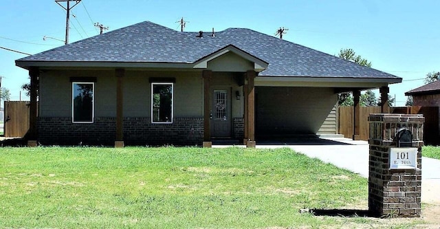 view of front of home featuring a carport, fence, brick siding, a shingled roof, and a front yard