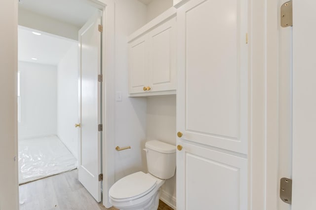 bathroom with hardwood / wood-style flooring and toilet