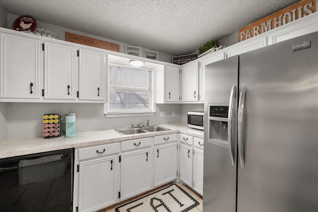 kitchen with appliances with stainless steel finishes, sink, a textured ceiling, and white cabinets