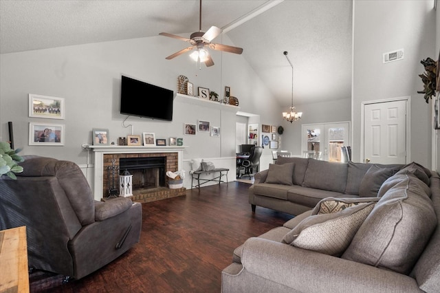 living room with high vaulted ceiling, a brick fireplace, a textured ceiling, dark hardwood / wood-style flooring, and ceiling fan with notable chandelier