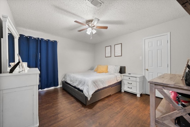 bedroom featuring dark hardwood / wood-style floors, a textured ceiling, and ceiling fan