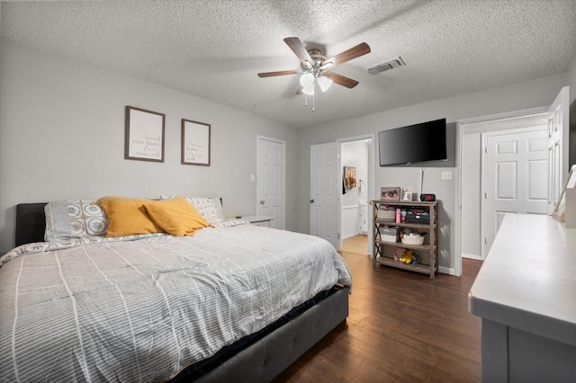 bedroom featuring dark hardwood / wood-style flooring, a textured ceiling, and ceiling fan