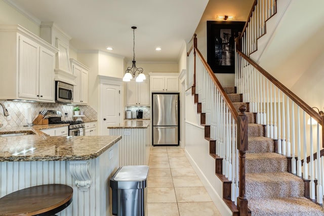 kitchen with sink, white cabinetry, hanging light fixtures, light tile patterned floors, and appliances with stainless steel finishes