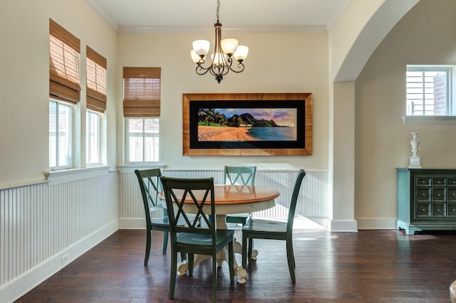 dining space with ornamental molding, dark hardwood / wood-style flooring, and a chandelier