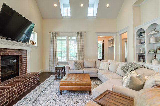 living room with a towering ceiling, hardwood / wood-style floors, and a fireplace