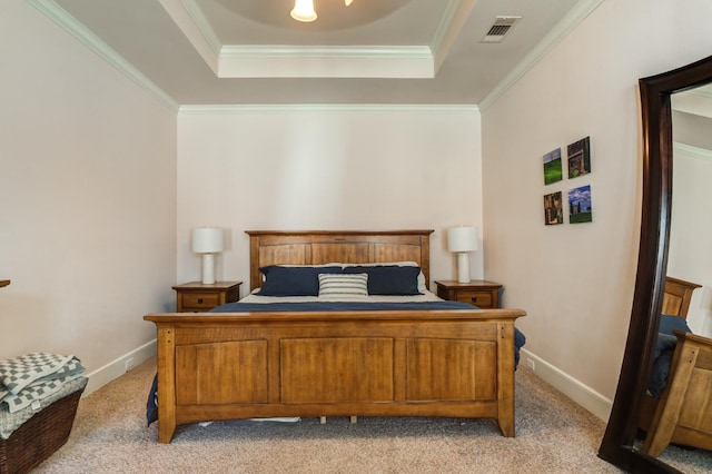 bedroom with crown molding, a tray ceiling, and light carpet