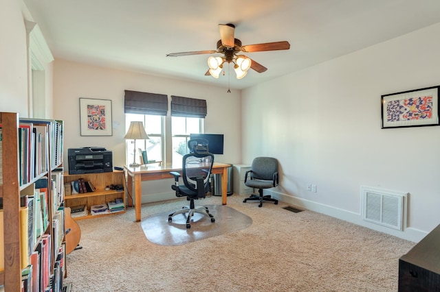 carpeted home office featuring ceiling fan