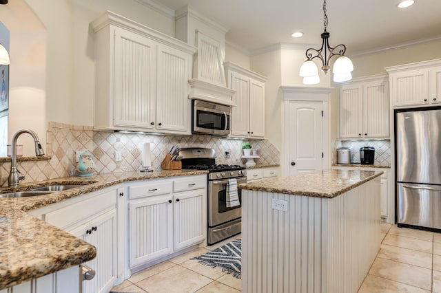 kitchen with sink, white cabinetry, hanging light fixtures, stainless steel appliances, and light stone counters