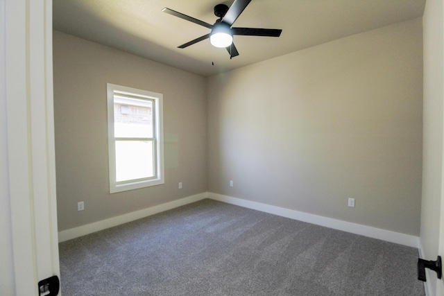 unfurnished room with a ceiling fan, dark colored carpet, and baseboards