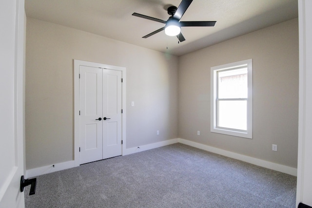 unfurnished room featuring baseboards, a ceiling fan, and carpet