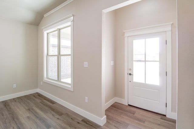 entryway with baseboards, lofted ceiling, and light wood-style floors