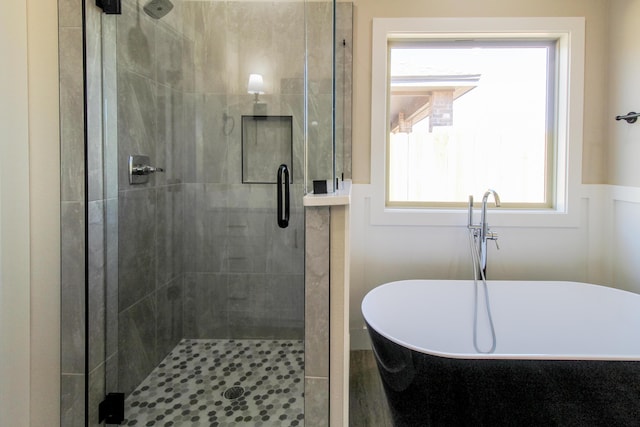 full bathroom featuring a freestanding tub and a shower stall