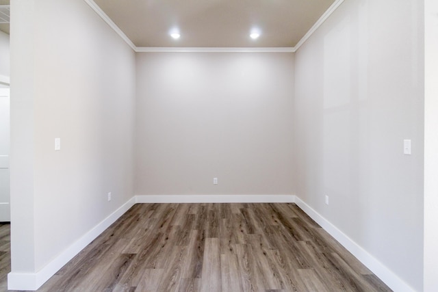 empty room featuring crown molding, recessed lighting, wood finished floors, and baseboards