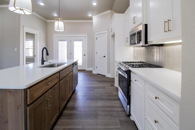 kitchen featuring decorative backsplash, white cabinets, a sink, stainless steel appliances, and ornamental molding