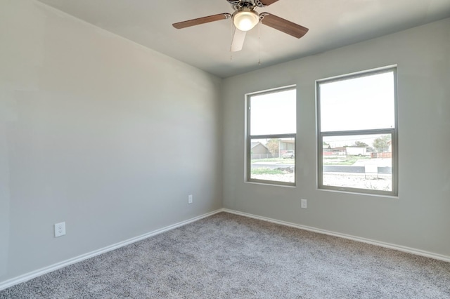 carpeted spare room featuring ceiling fan