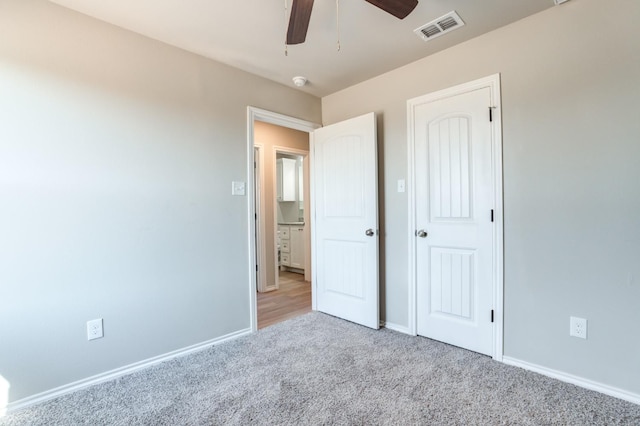 unfurnished bedroom with ceiling fan and light carpet