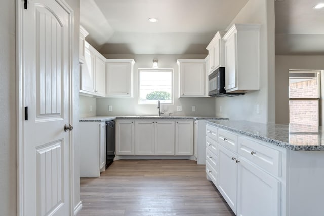 kitchen with light stone counters, sink, black appliances, and white cabinets