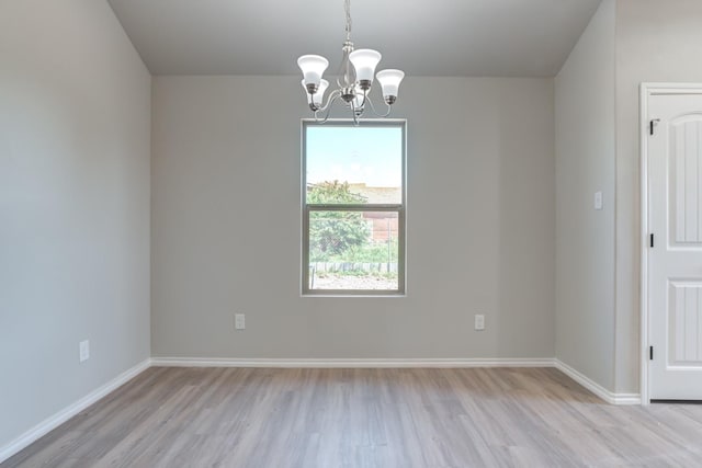 unfurnished room with an inviting chandelier and light hardwood / wood-style floors