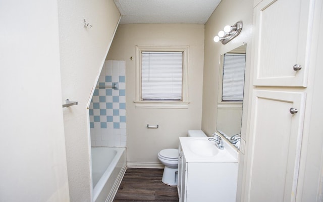 full bathroom featuring tiled shower / bath, hardwood / wood-style flooring, vanity, toilet, and a textured ceiling