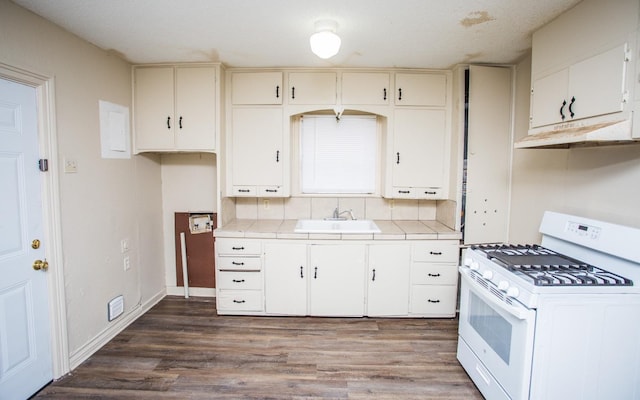 kitchen with dark hardwood / wood-style flooring, white gas range, decorative backsplash, and sink