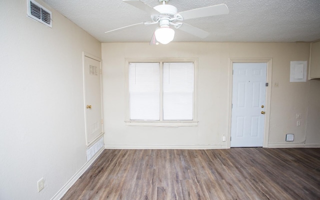 empty room with ceiling fan, dark hardwood / wood-style floors, and a textured ceiling