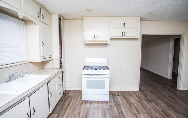 kitchen featuring white gas range, sink, and white cabinets