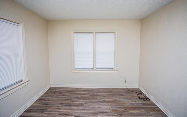 unfurnished room featuring dark hardwood / wood-style flooring and a textured ceiling