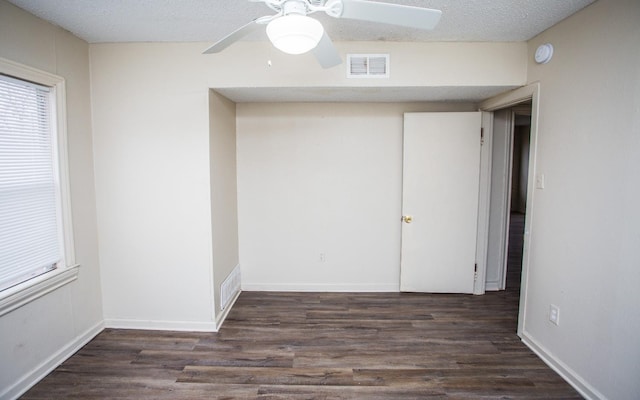 spare room featuring ceiling fan, a textured ceiling, and dark hardwood / wood-style flooring