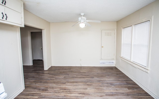 unfurnished dining area featuring ceiling fan, dark hardwood / wood-style floors, a wealth of natural light, and a textured ceiling