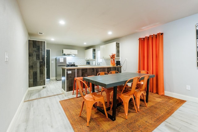 dining room featuring sink and light hardwood / wood-style flooring