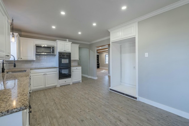 kitchen with white cabinetry, sink, double oven, and dark stone countertops