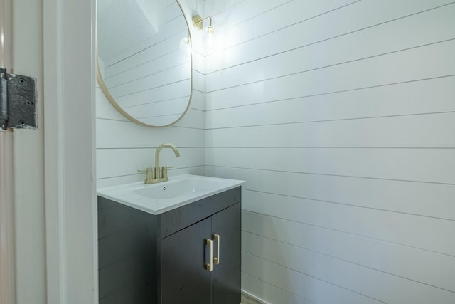 bathroom with vanity and wood walls