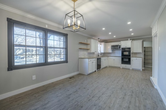 kitchen featuring hanging light fixtures, white cabinetry, crown molding, and black appliances