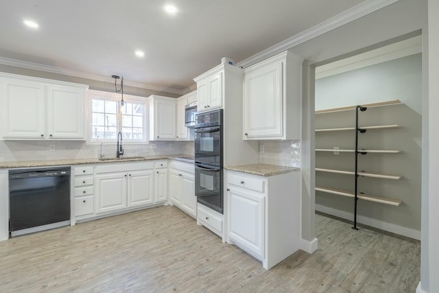 kitchen with white cabinetry, sink, ornamental molding, and black appliances