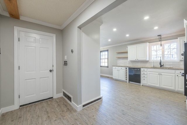 kitchen featuring sink, hanging light fixtures, black dishwasher, light hardwood / wood-style floors, and white cabinets