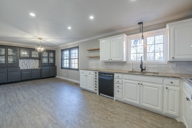 kitchen featuring pendant lighting, dishwasher, sink, white cabinets, and light stone counters