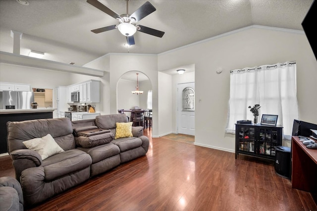 living room featuring lofted ceiling, crown molding, a textured ceiling, dark hardwood / wood-style floors, and ceiling fan