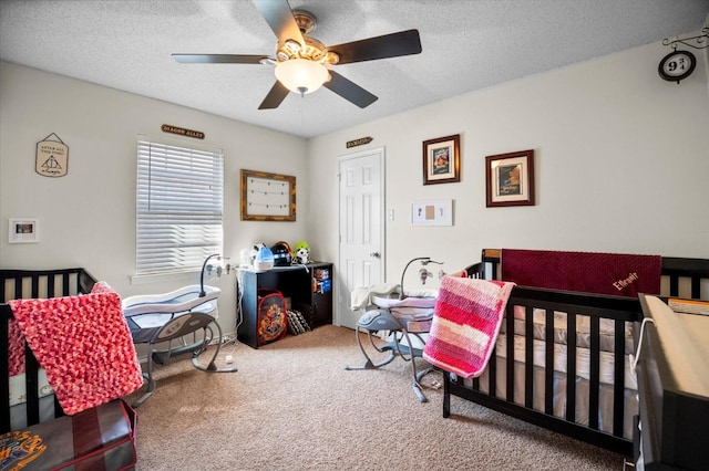 carpeted bedroom with ceiling fan and a textured ceiling