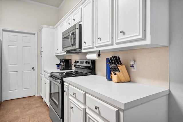 kitchen with white cabinetry, ornamental molding, and appliances with stainless steel finishes