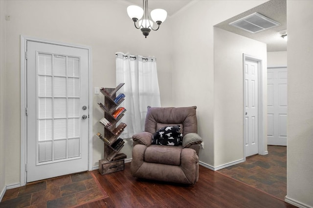 living area with dark wood-type flooring and a notable chandelier