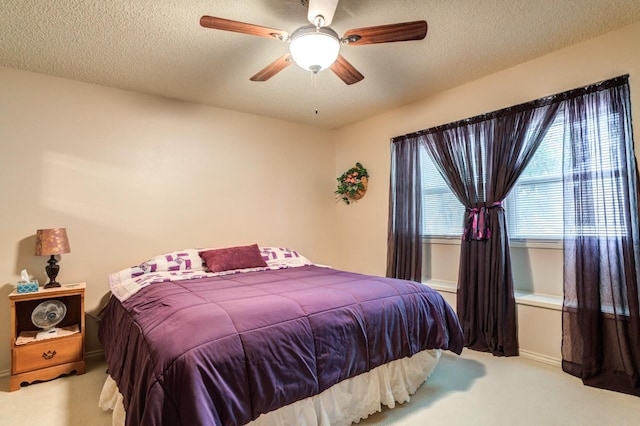 bedroom featuring carpet flooring, a textured ceiling, and ceiling fan